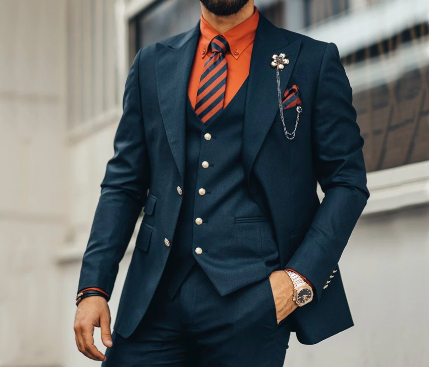 Com lê double-breasted màu navy với cà vạt lụa đỏ nổi bật.