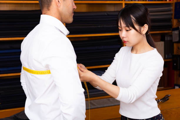 Thợ may đo áo vest cho khách tại tiệm may chuyên nghiệp